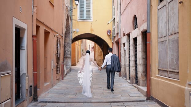 Happy newlyweds at a photo shoot. Action. Running newlyweds on the street in good weather laughing and having fun. High quality 4k footage