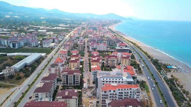 Beautiful view from the drone. You can see a beautiful ocean and large houses with a road, you can see beautiful green mountains from behind