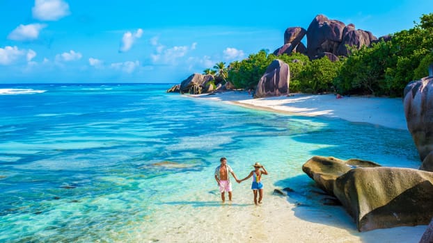 Anse Source d'Argent, La Digue Seychelles, a young couple of men and women on a tropical beach during a luxury vacation in Seychelles. Tropical beach Anse Source d'Argent, La Digue Seychelles