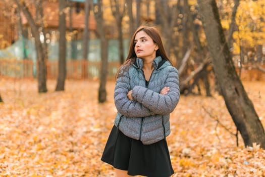 Beautiful indian woman generation z relaxing and feeling nature at autumn park in fall season. Diversity and gen z youth.