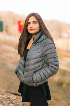 Close up portrait of pretty indian young woman enjoying warm autumn sunny day vacation outdoors. Generation z and gen z concept. Fall Season.