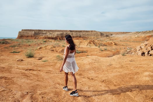 Woman in mesh clothes in the desert on a walk in a sand quarry