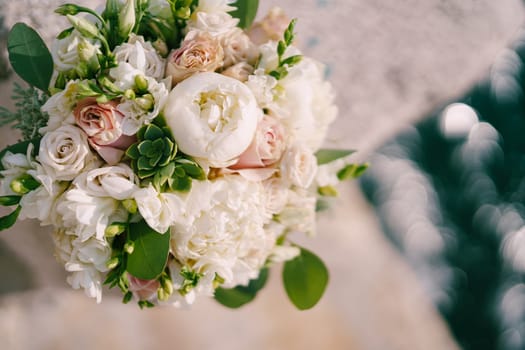 Luxurious bridal bouquet of peonies, roses and green branches. Top view. High quality photo