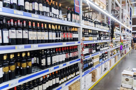 Tyumen, Russia-December 11, 2023: Collection of wines in a luxury alcohol store. Bottles of various wines are beautifully placed on the counter.