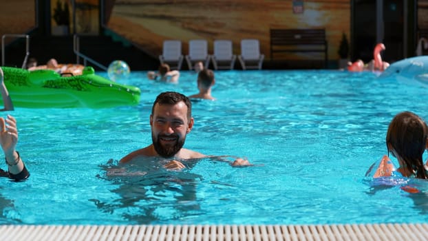 Happy family spending time in outdoors hotel swimming pool. Clip. Concept of travelling with children