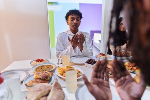 In the sacred month of Ramadan, a diverse Muslim family comes together in spiritual unity, fervently praying to God before breaking their fast, capturing a moment of collective devotion, cultural diversity, and familial joy in the midst of the holy celebration.