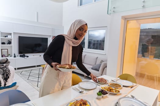 A young Arab woman gracefully prepares iftar for her family, delicately serving the table in the sacred month of Ramadan, capturing the essence of familial joy, cultural tradition, and spiritual devotion.