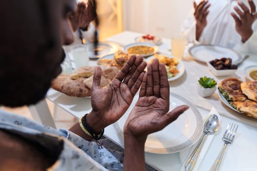 In the sacred month of Ramadan, a diverse Muslim family comes together in spiritual unity, fervently praying to God before breaking their fast, capturing a moment of collective devotion, cultural diversity, and familial joy in the midst of the holy celebration.