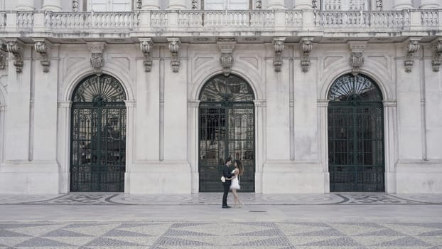 Attractive young wedding couple on the background of historical architecture of an old city. Action. Wedding photosession
