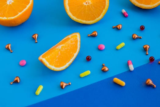 Multivitamins and supplements with fresh orange and lamon on white wooden background.