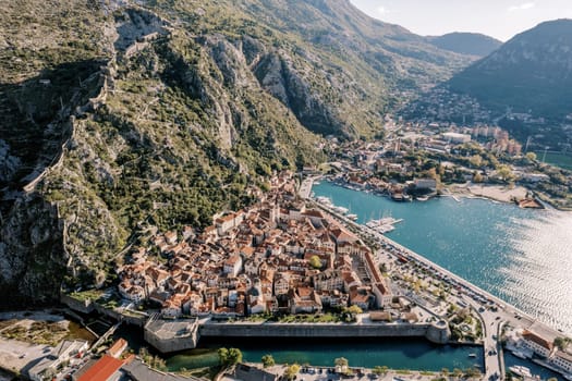 Town of Kotor on the shore of a bay with canals at the foot of the mountains. Montenegro. Drone. High quality photo
