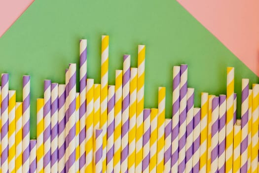 Drinking straws for party on white background. Top view of colorful paper disposable eco-friendly straws for cocktails.