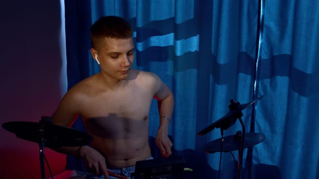 A young caucasian man drummer plays a drum kit in a music studio. Media. Creating music and art, rock band member is rehearsing, studying