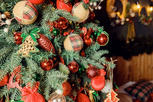 Christmas decorations on the holiday tree.Many colorful balls garland glowing lamps and red berries on the branches are sprinkled with snow.