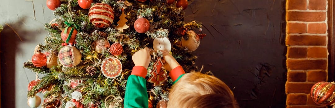 Close up of little Caucasian girl's hands putting ornaments on Christmas tree styled in blue and grey