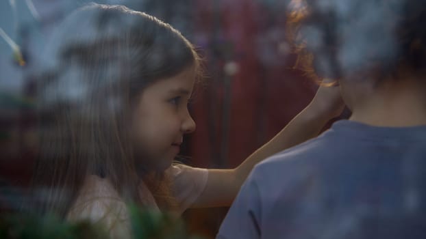 Rear view of girl and boy talking at home. Stock footage. Children communicate sweetly at home or at party. Two children are talking over needlework at home.