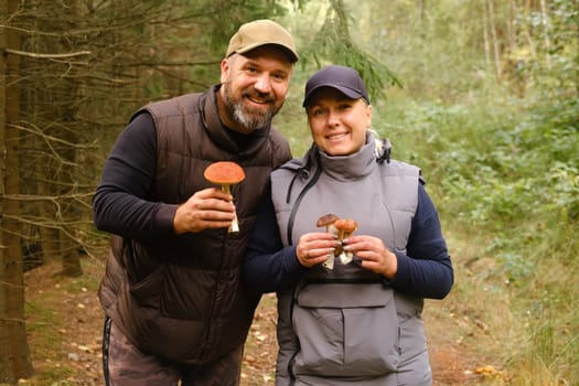 Two mushroom pickers in the forest are holding aspen trees in their hands. Mushrooms in the forest. Mushroom picking.