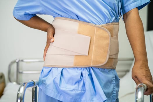 Asian lady patient use walker in hospital to support walking.