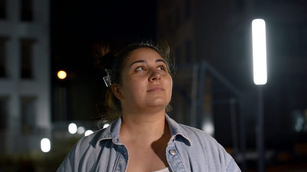 Brunette woman outdoors at night looking at dark night sky. Media. Romantic lady on a summer night