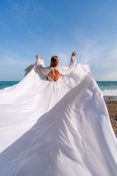 Woman beach white dress flying on Wind. Summer Vacation. A happy woman takes vacation photos to send to friends