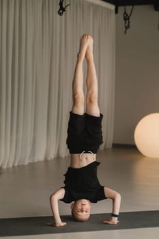 A child practices yoga poses indoors. Children's yoga.