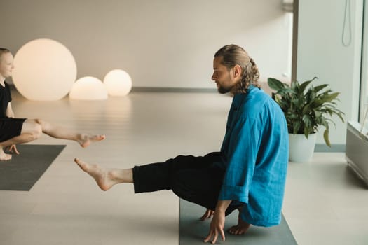 Children do yoga in the gym under the guidance of an instructor. Children's gymnastics.