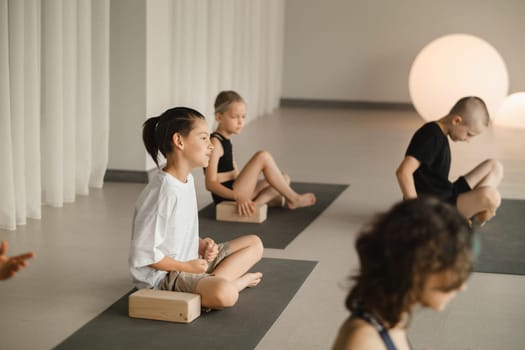 Children do yoga in the gym on support blocks. Children's gymnastics.