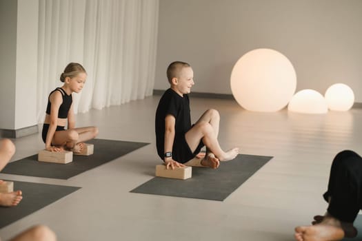 Children do yoga in the gym on support blocks. Children's gymnastics.