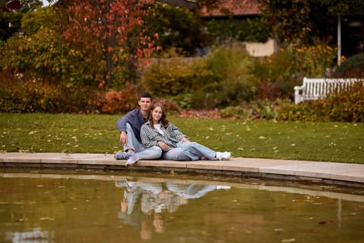 lovely young couple kissing outdoors in autumn. Loving couple walking in nature. Autumn mood. Happy man and woman hugging and kissing in autumn. Love. Fashionable couple outdoors. Fashion, people and lifestyle. Stylish couple in autumn outfit.