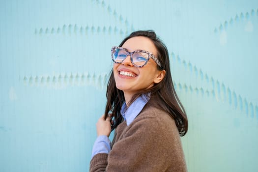 Woman wearing glasses and casual style smiles broadly outdoor. Business woman with positive expression, smile broadly, dressed in casual style clothing. Happy adorable glad woman rejoices success