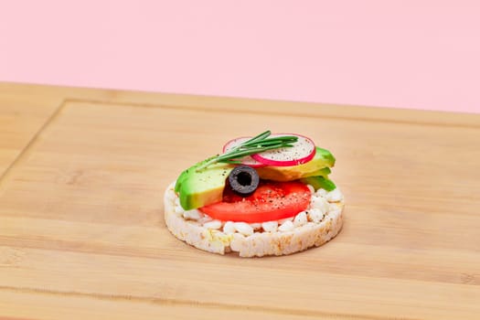 Rice Cake Sandwich with Avocado, Tomato, Cottage Cheese, Olives and Radish on Bamboo Cutting Board. Easy Breakfast. Diet Food. Quick and Healthy Sandwiches. Crispbread with Tasty Filling