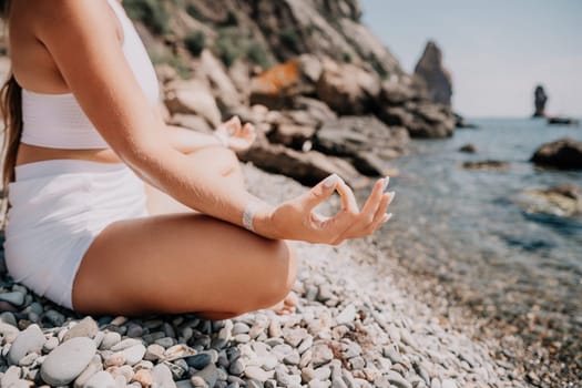 Woman sea yoga. Back view of free calm happy satisfied woman with long hair standing on top rock with yoga position against of sky by the sea. Healthy lifestyle outdoors in nature, fitness concept.