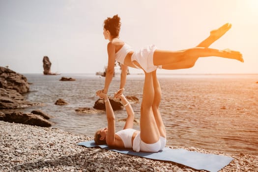 Woman sea yoga. Back view of free calm happy satisfied woman with long hair standing on top rock with yoga position against of sky by the sea. Healthy lifestyle outdoors in nature, fitness concept.