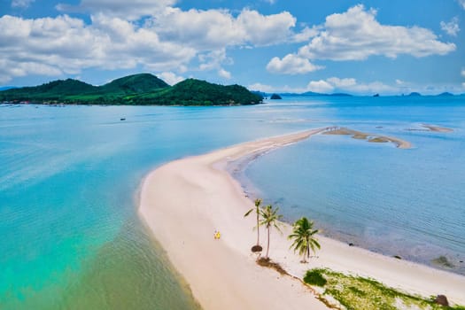 a couple of men and women walking on the beach at the Island Koh Yao Yai Thailand, a beach with white sand and palm trees. Laem Had Beach Koh Yao Yai