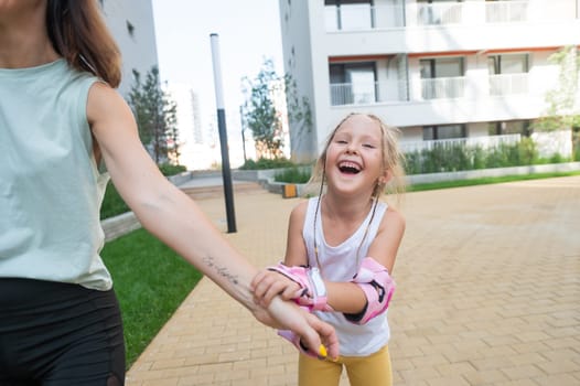 Mother helps daughter learn to roller skate