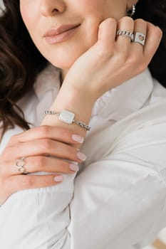 Women Jewelry concept. Woman's hands close up wearing rings and necklace modern accessories elegant lifestyle.