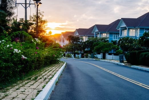 Modern cottages row road sidewalk two story buildings residential villas village New Estate Reflection dawn Sun in windows.