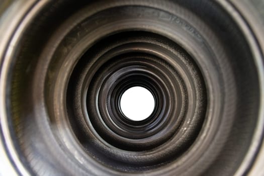 A tunnel of new car tires standing on a store counter with concentrated rings and a wheel in the center