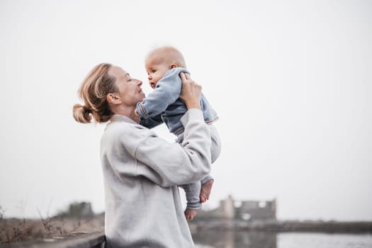 Tender woman caressing her little baby boy infant child outdoors on autumn trip to Secovlje salinas landscape park, Slovenia. Mother's unconditional love for her child