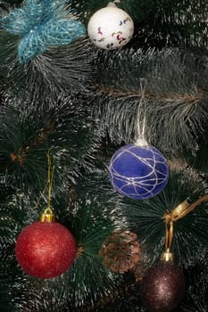 Beautiful background with bokeh and snowflakes for a Christmas greeting card with decorations on the branches of the tree and a greeting message.