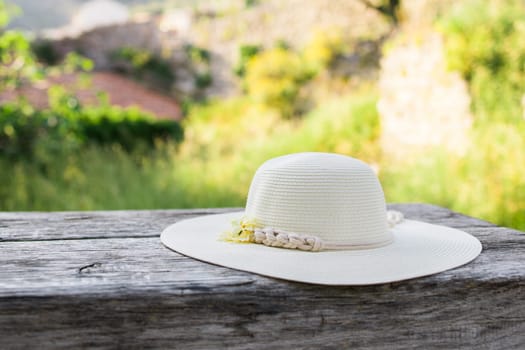 Summer nature background. Braided straw hat on bench in garden. spring season. Rustic composition nature. Relax voyage time. Copy space and mock up place for text.