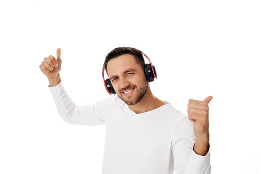 happy handsome young man in headphones listening to music and dancing isolated on white background.