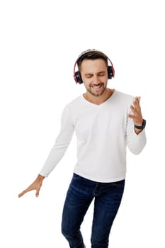 handsome young man in headphones listening to music and dancing isolated on white background.