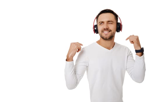 handsome smiling young man in headphones listening to music, dancing and singing isolated on white background.