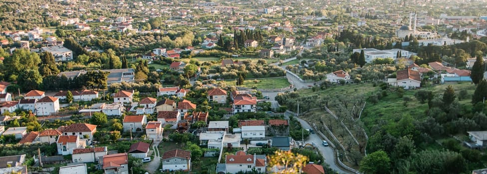 Banner mosque and panoramic cityscape of town Bar in Montenegro with road and houses, aerial view. Copy space and empty place for text.