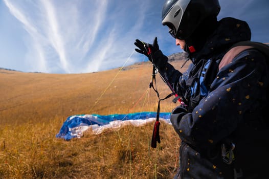 Point of view of a skydiver piloting his parachute. Hands holding the lines of their parachute, wide angle view.