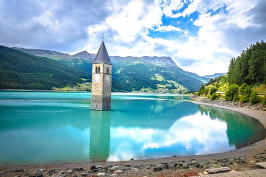 Submerged bell Tower of Curon Venosta or Graun im Vinschgau on Lake Reschen landscape view, South Tyrol region Italy