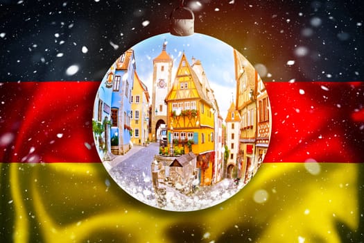 Rothenburg ob der Tauber winter snow view through christmas ball on german flag, winter concept of Germany