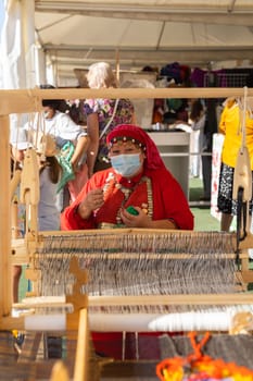 UFA, RUSSIA - JULY 10, 2021: Bashkir woman make carpet during Folkloriada in Ufa