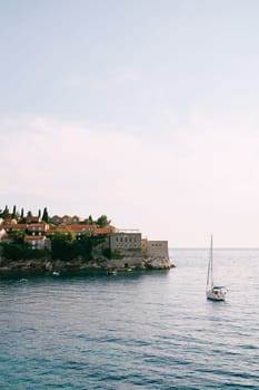 Sailing yacht sails to the island of Sveti Stefan. Montenegro. High quality photo